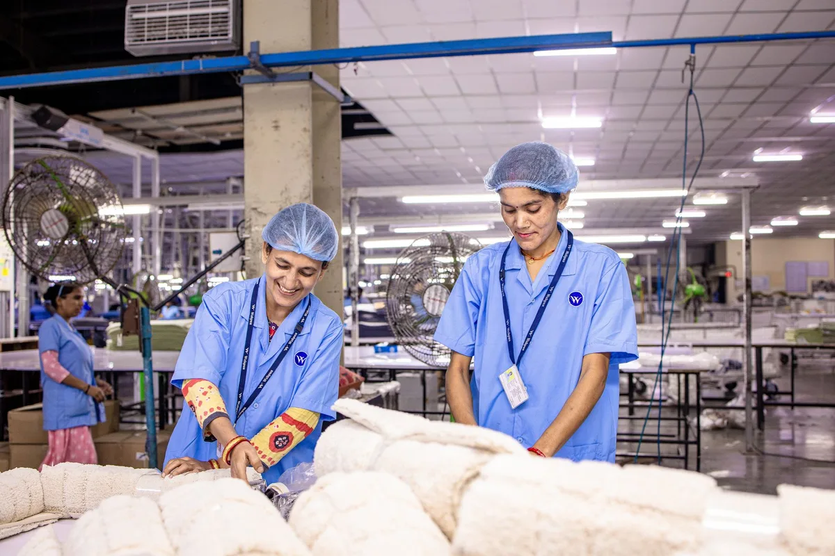 Two quality inspectors checking finished goods on a factory floor